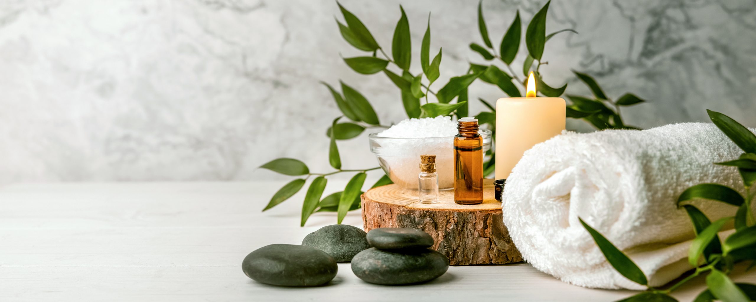 beauty treatment items for spa procedures on white wooden table.